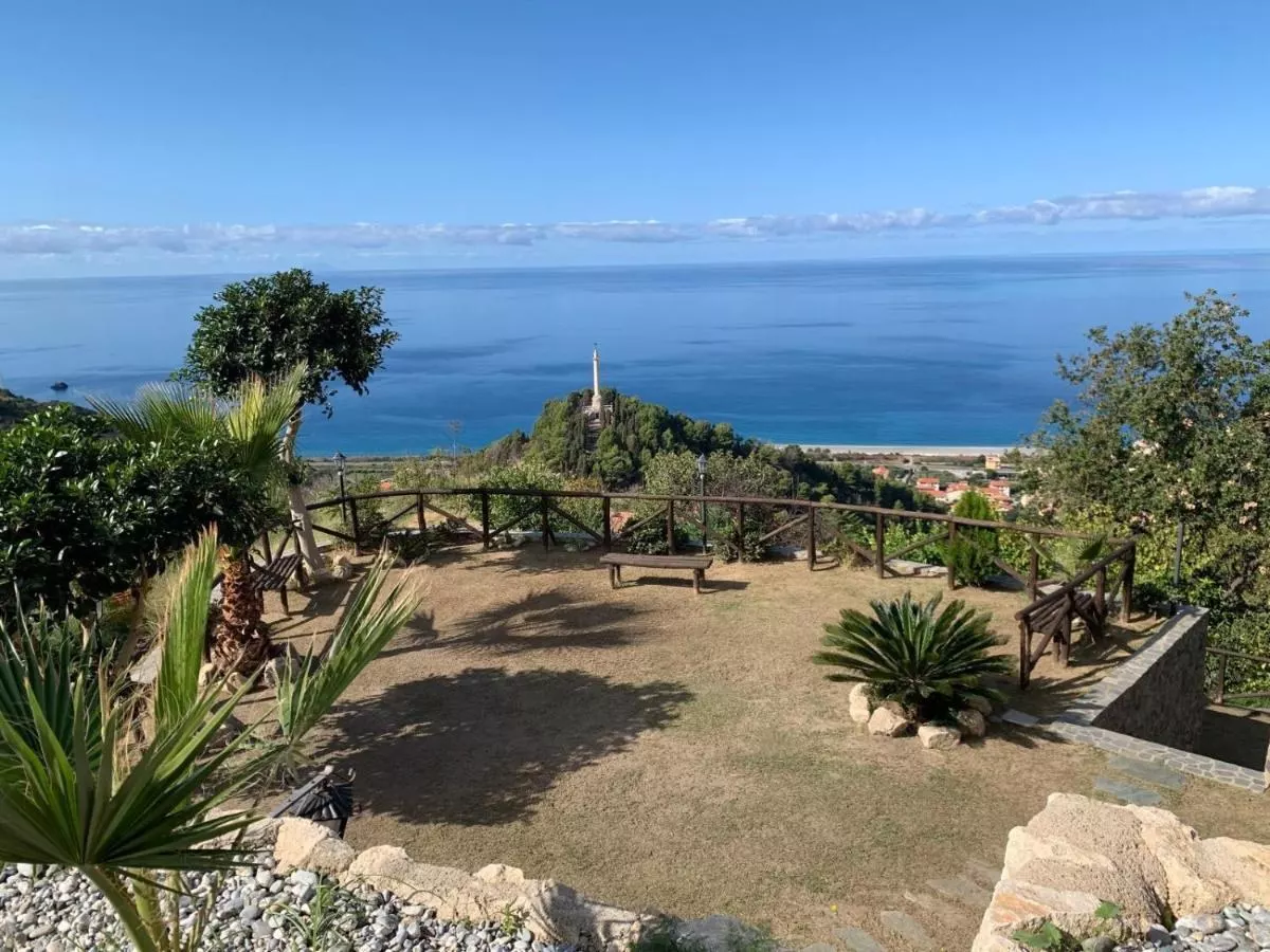 Il giardino con palme e ulivi sopra il mare